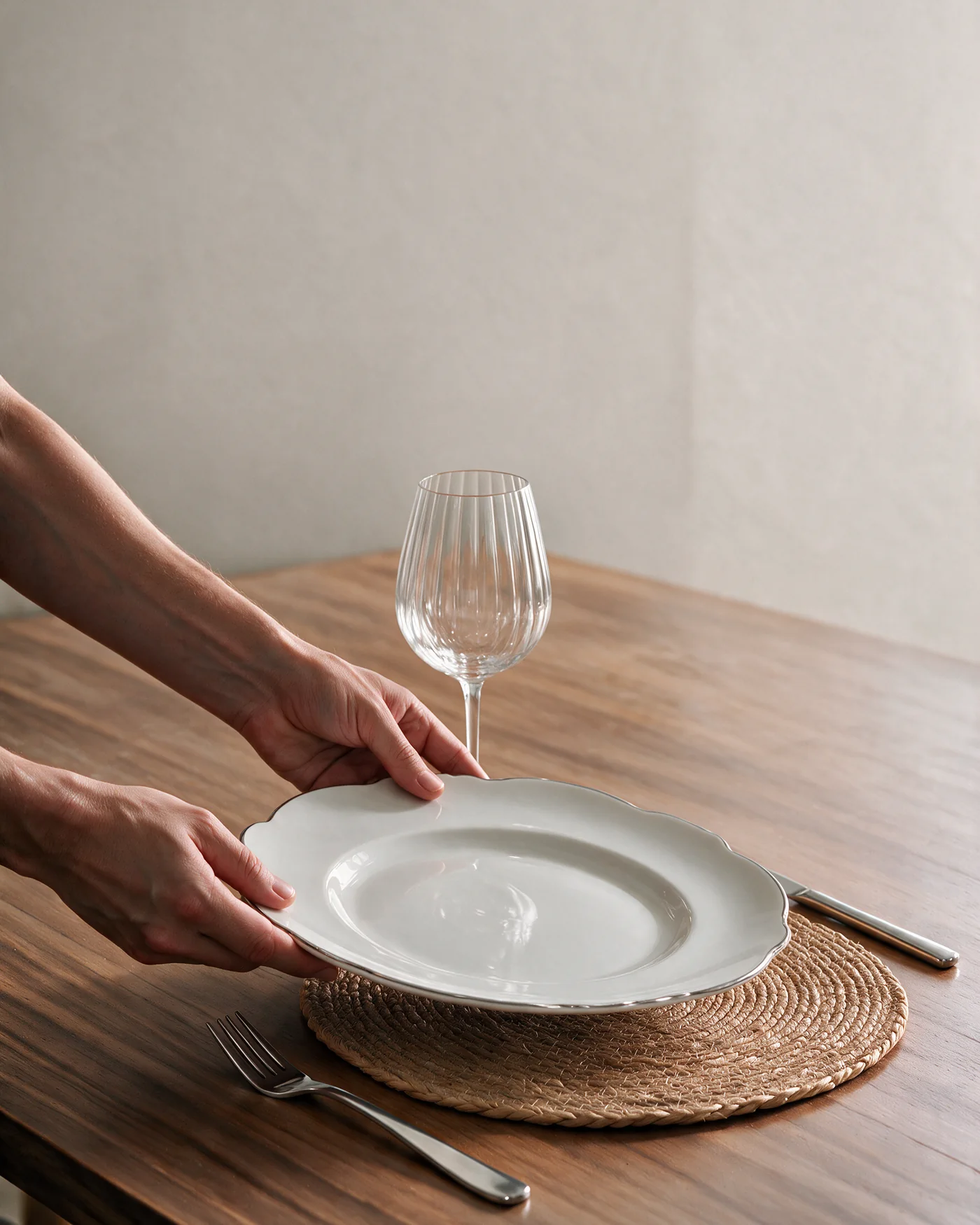 Mãos posicionam prato Maldivas Wolff de 28 cm em proporção realista sobre lugar americano de fibra natural de 37 cm
