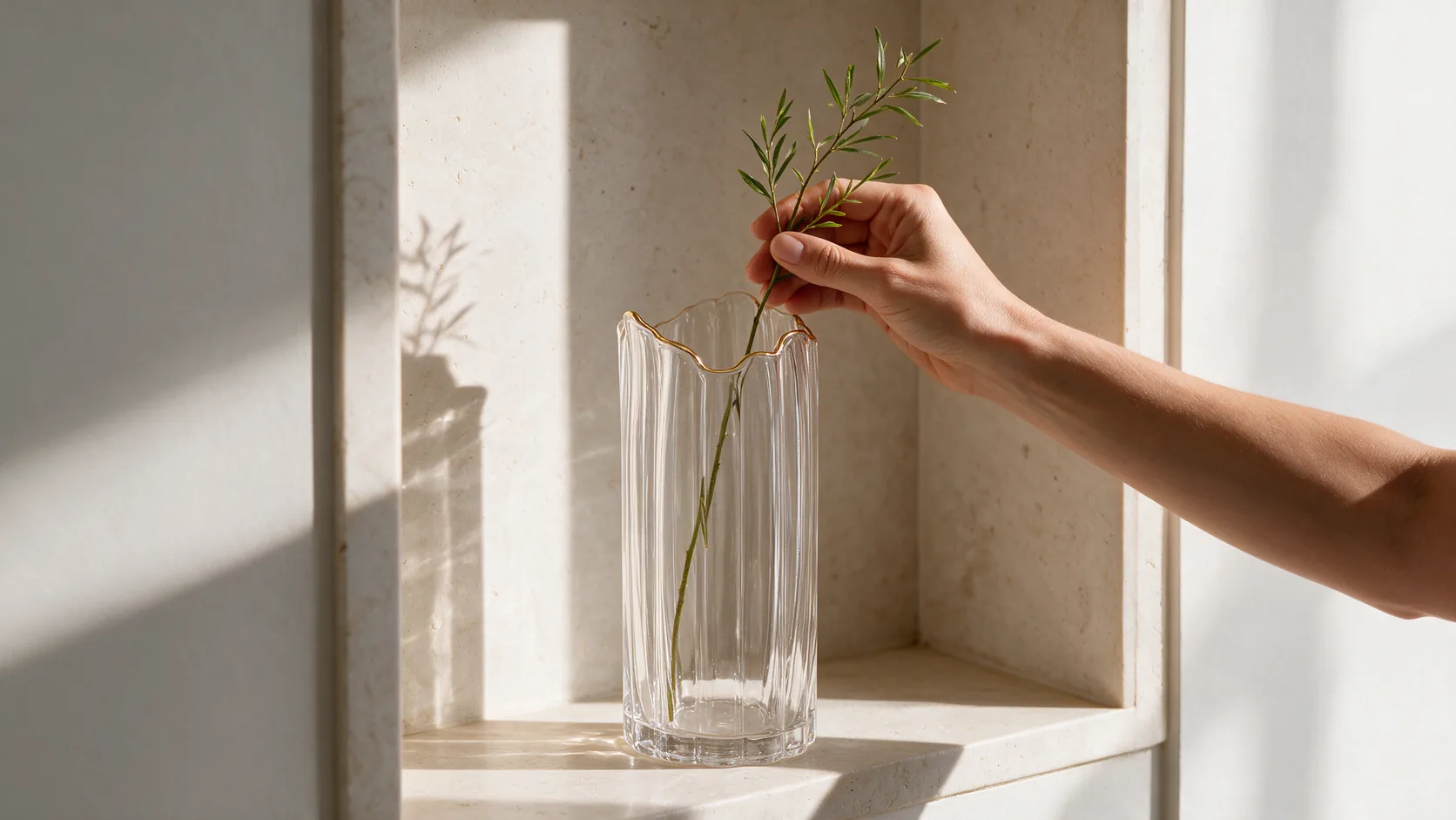 Pessoa decorando um ambiente com vaso de vidro Wolff