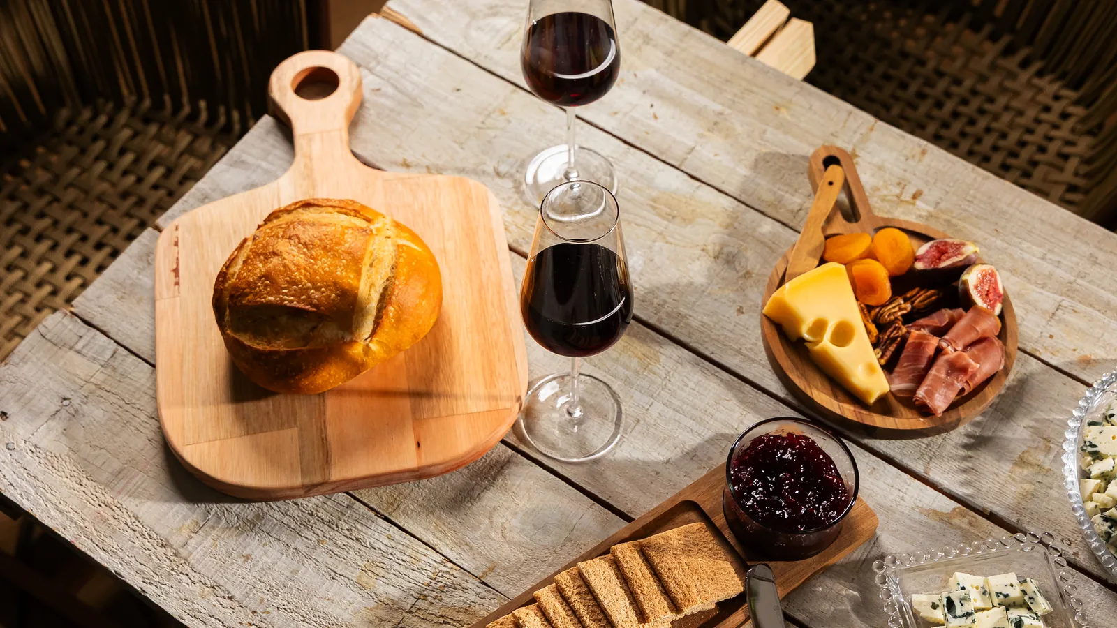 Mesa de queijos e vinhos com tábuas e taças Wolff